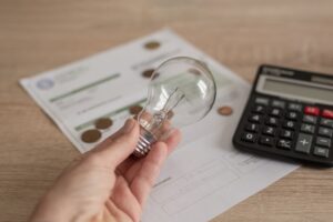 Hand som håller glödlampa, miniräknare, avtal